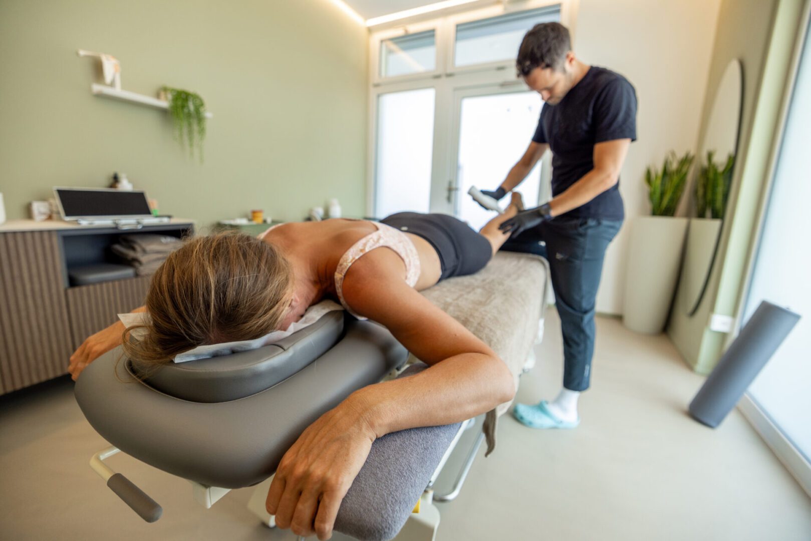 Therapist using device on patient's leg